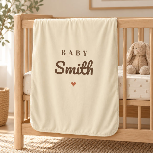 Baby Surname swaddle blanket in oat, styled photo 1