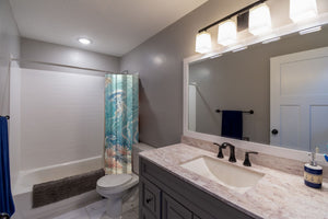Jellyfish Garden Ocean shower curtain pulled open in a gray kids bathroom