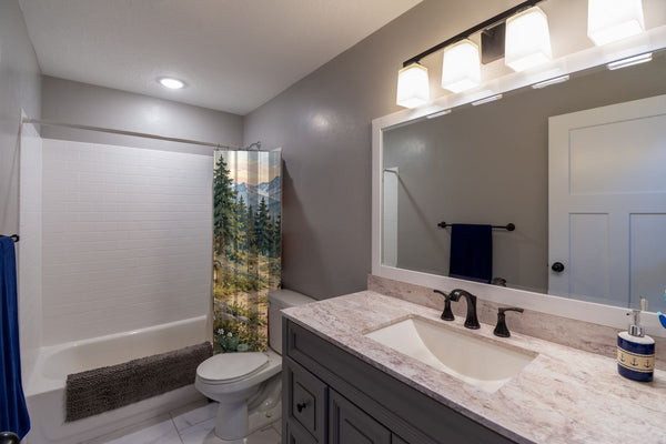 Mountain Camp Camping shower curtain pulled open in a gray kids bathroom