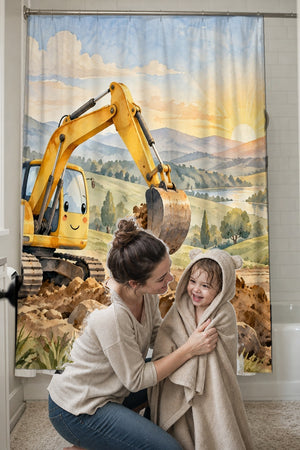 Mom drying her toddler in a hooded towel in front of the Sunrise Excavator shower curtain