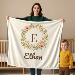 Floral Monogram toddler sherpa blanket in cream, held by a mom