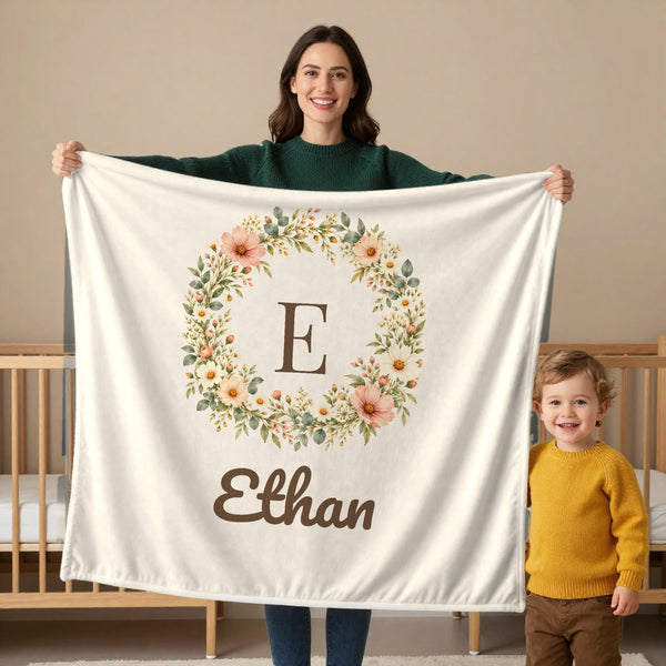 Floral Monogram toddler sherpa blanket in cream, held by a mom