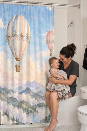 Mom holding her baby on the tub edge next to the Mountain Hot Air Balloons shower curtain