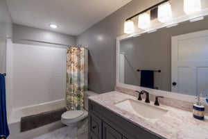 Woodland Castle Fairy Tale shower curtain pulled open in a gray kids bathroom