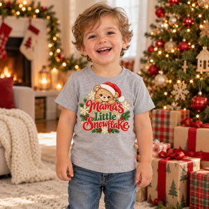 Child wearing the Mama's Little Snowflake toddler t-shirt at Christmas
