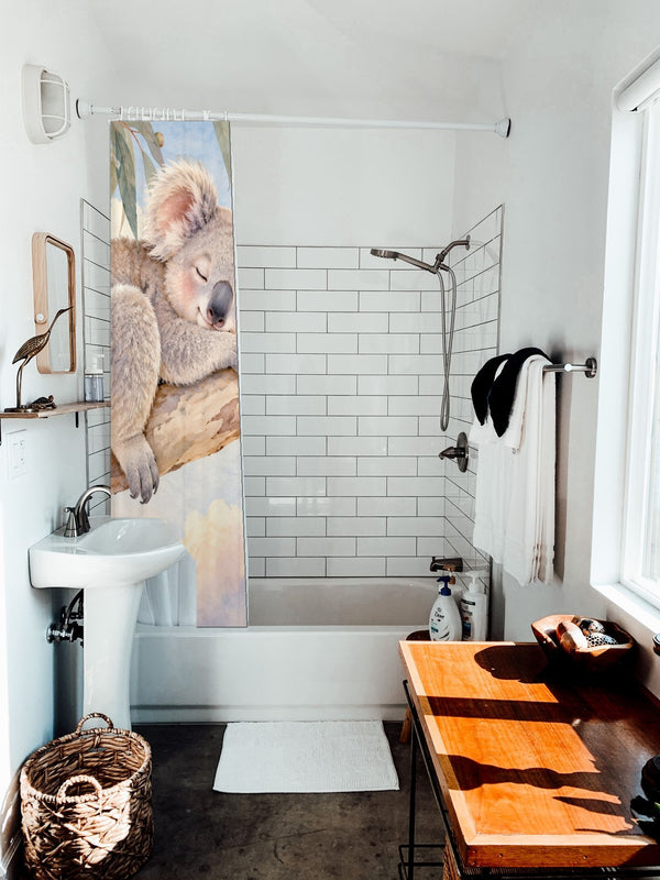 Sleepy Koala shower curtain hanging on the rod over a white bathtub