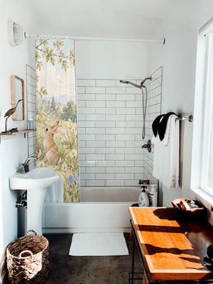 Rainbow Meadow Bunny shower curtain hanging on the rod over a white bathtub