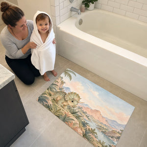 Mom and toddler in a hooded towel next to the Baby Triceratops Dinosaur bath mat