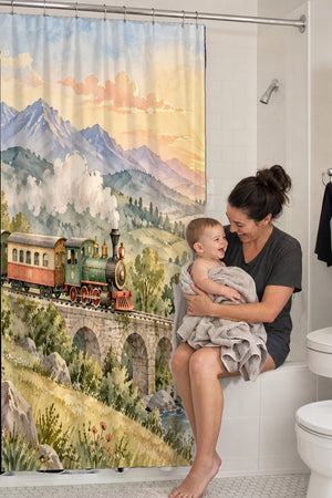 Mom holding her baby on the tub edge next to the Sunrise Train shower curtain