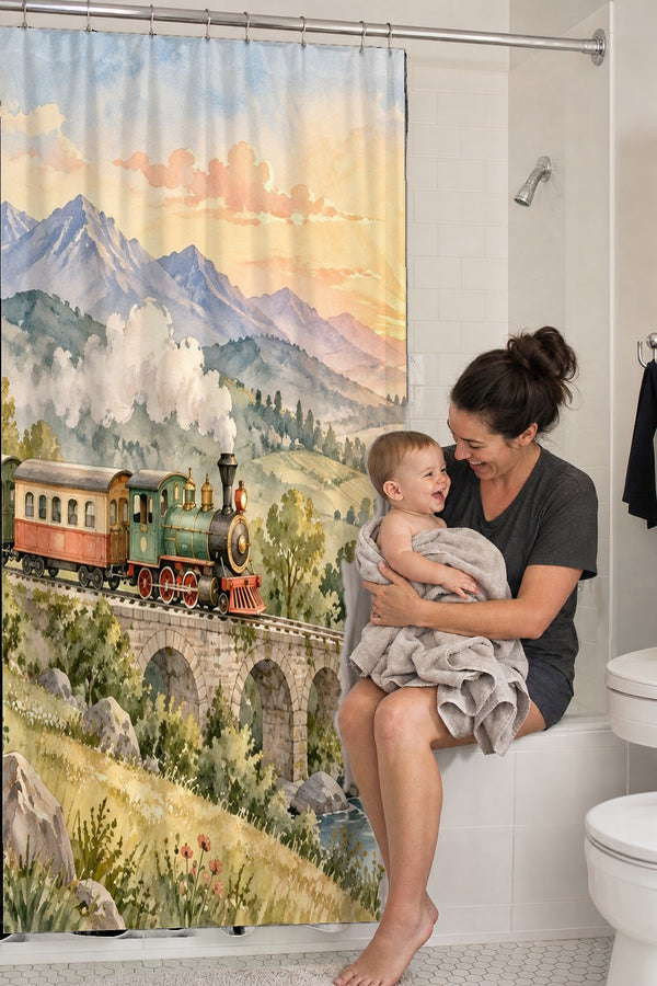Mom holding her baby on the tub edge next to the Sunrise Train shower curtain