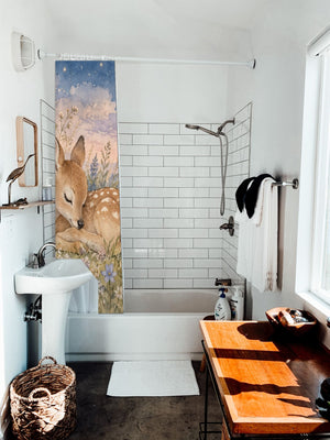 Resting Deer shower curtain hanging on the rod over a white bathtub