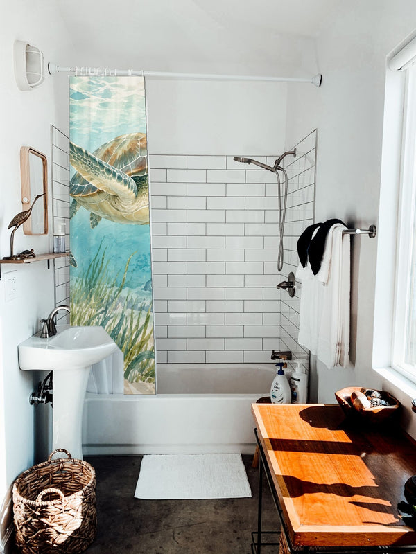 Sea Turtles Ocean shower curtain hanging on the rod over a white bathtub