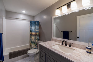 Moonlit Train shower curtain pulled open in a gray kids bathroom