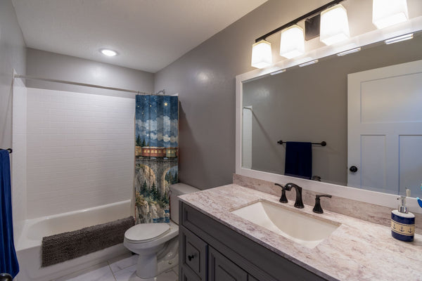 Moonlit Train shower curtain pulled open in a gray kids bathroom