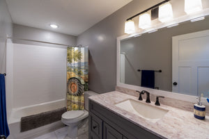 Farm Tractor shower curtain pulled open in a gray kids bathroom