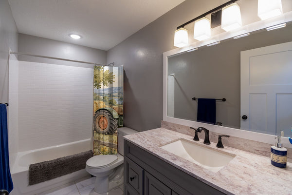 Farm Tractor shower curtain pulled open in a gray kids bathroom