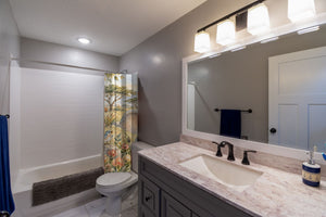 Elephant Drum shower curtain pulled open in a gray kids bathroom