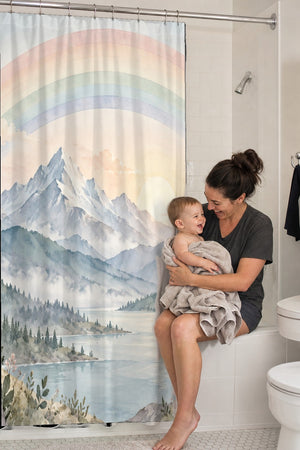 Mom holding her baby on the tub edge next to the Sunrise Lake Rainbow shower curtain