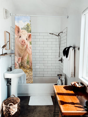 Piglet Family Farm shower curtain hanging on the rod over a white bathtub