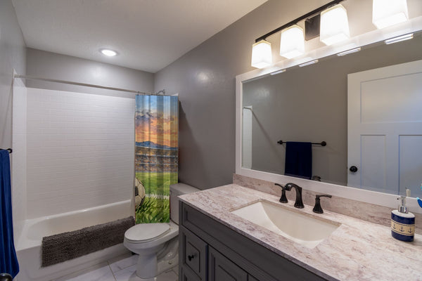 Stadium Sunset Soccer shower curtain pulled open in a gray kids bathroom