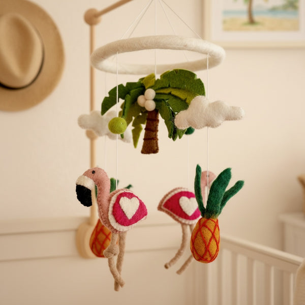Felt tropical baby mobile seen from a low angle against a softly blurred cream wall
