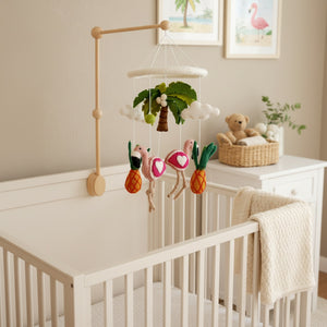 Felt tropical trio baby mobile hanging above a light wood crib in a calm, bright nursery