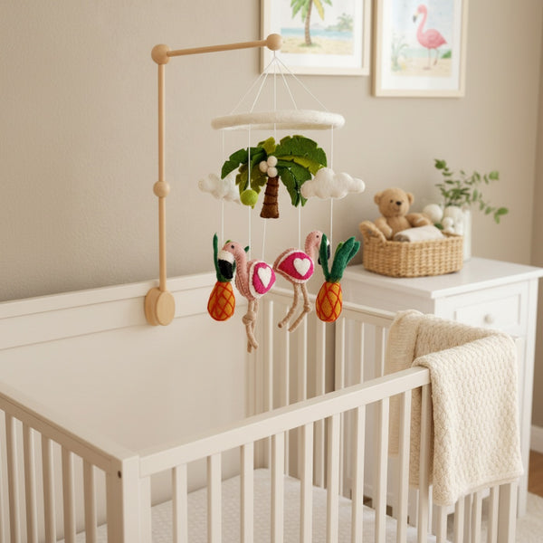 Felt tropical trio baby mobile hanging above a light wood crib in a calm, bright nursery
