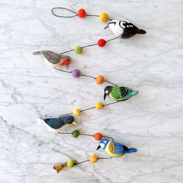 Felt bird garland laid flat, showing five needle felted wool birds and colorful felt balls