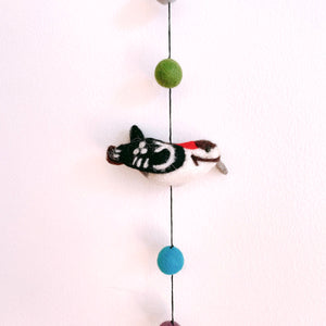 Close up of a felt woodpecker bird on the garland, showing detailed wool felting and felt balls