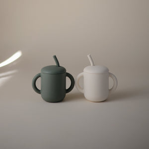 Silicone training cup with straw at a 55-degree angle, perfect for toddlers learning to drink independently.