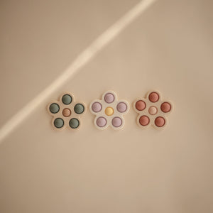 Colorful flower press toy for babies, promoting creativity and sensory play at a 31-degree angle.