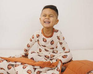 Football print quilted bamboo blanket for babies, 1.0 Tog, soft and cozy swaddle for comfort and warmth.