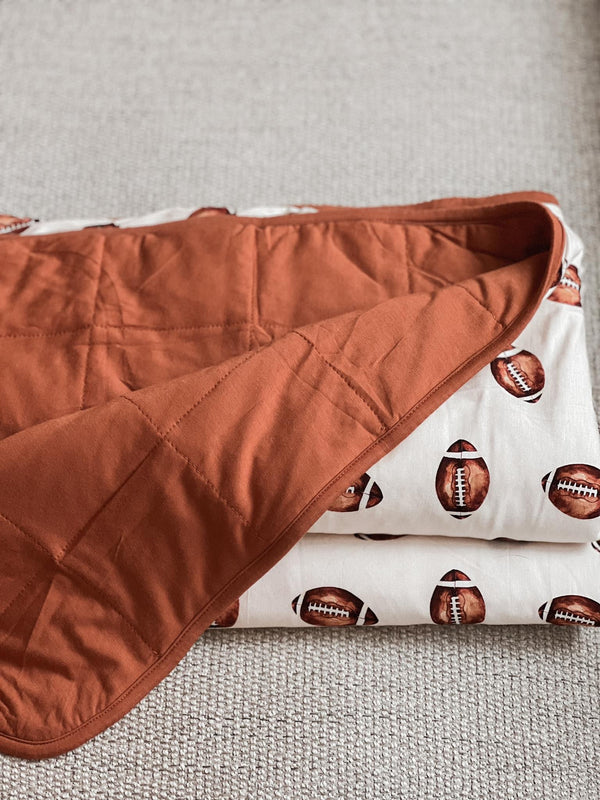 Football print quilted bamboo blanket for babies, 1.0 Tog, perfect for swaddling and cozy comfort.