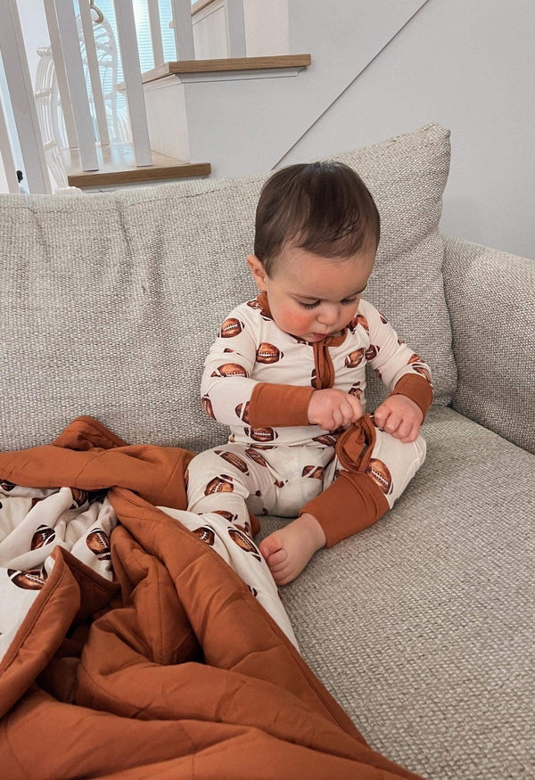 Football print quilted bamboo blanket for babies, 1.0 Tog, cozy and stylish swaddle for little ones.