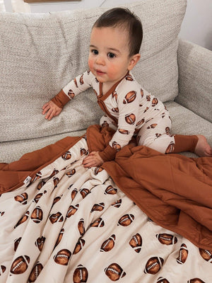 Football print quilted bamboo blanket for babies, 1.0 Tog, cozy and stylish swaddle for comfort and warmth.