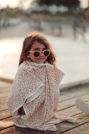 Organic cotton bathing towel poncho for babies in Sunset Meadow design, angled view showcasing softness and style.