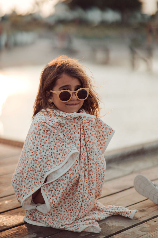 Organic cotton bathing towel poncho for babies in Sunset Meadow design, angled view showcasing softness and style.