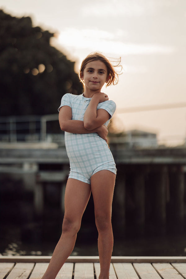 Short sleeve rashguard swimsuit in fern plaid, UPF protection, eco-friendly design, angle view.