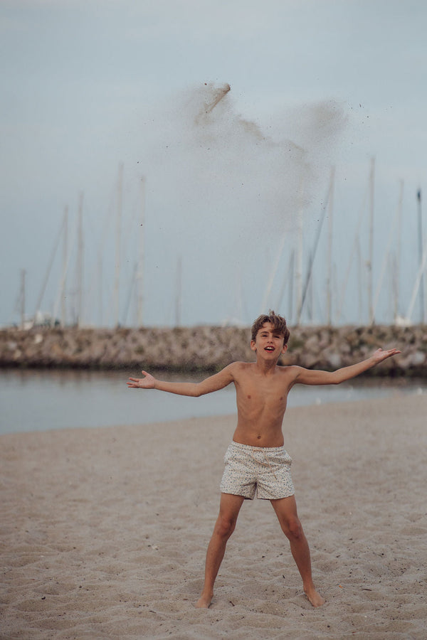 Baby swim trunks in Scandi floral design, UPF protection, made from recycled materials, angle view.