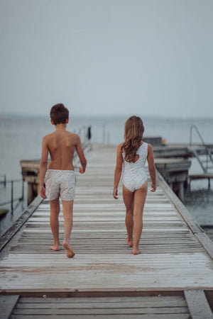 Baby swim trunks in Scandi floral design, UPF protected, made from recycled materials, shown at angle 10.