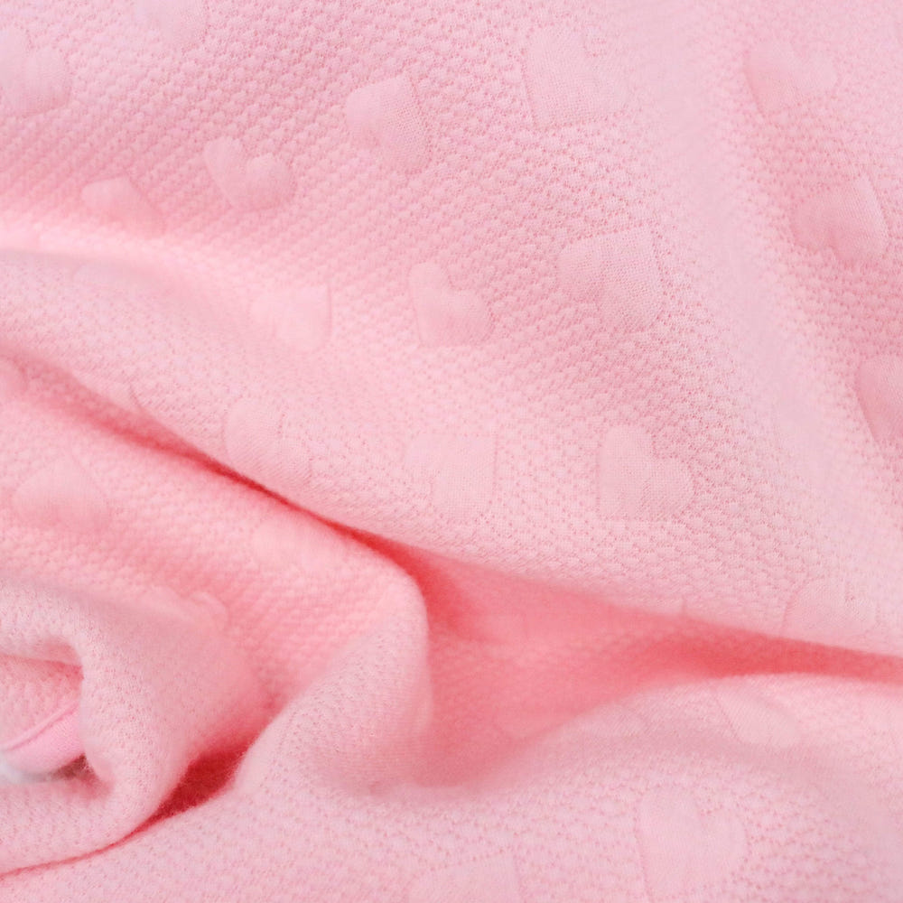 Soft pink knit baby blanket, perfect for keeping your little one cozy and stylish. Ideal for nurseries and baby gifts.
