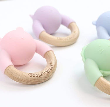 Wooden and silicone rattle teether in four colors, perfect for soothing baby's gums and sensory play.