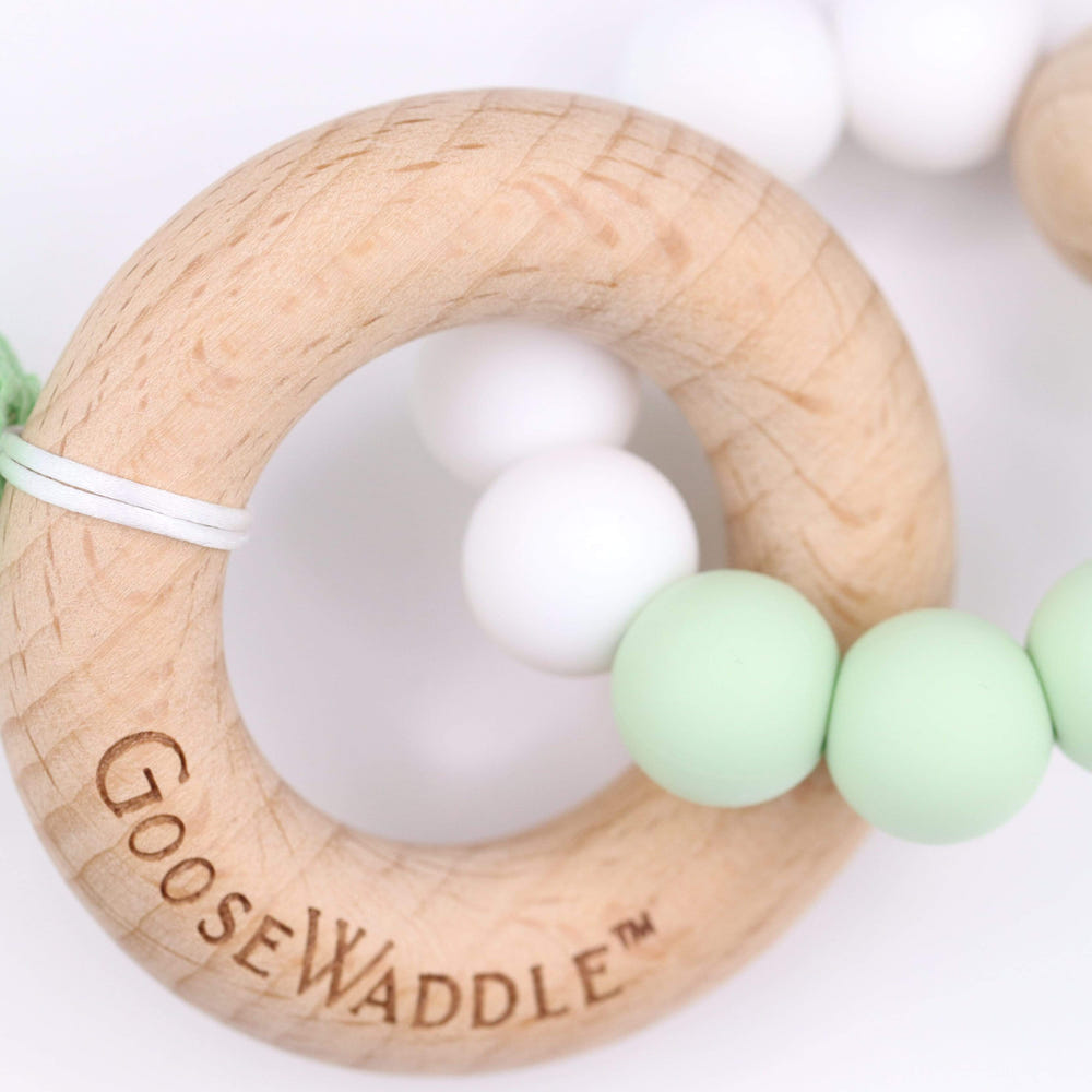 Mint wooden and silicone teether for babies, safe and soothing for teething relief.