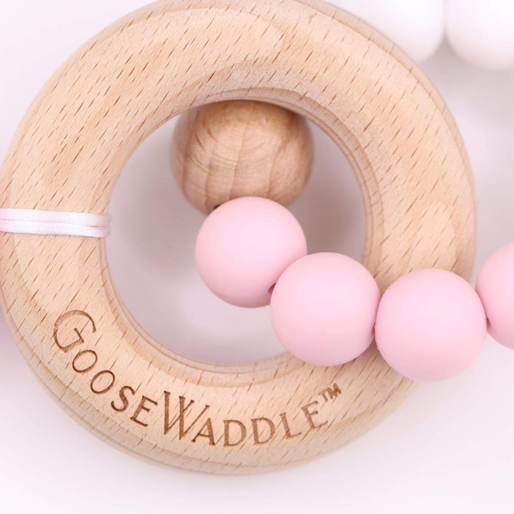 Pink wooden and silicone teether for babies, perfect for soothing gums and safe for little hands.