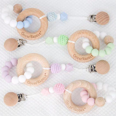 Attachable wooden and silicone teether with clasp in four colors for babies. Safe, stylish, and convenient.