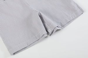Grey gingham puppies in truck shortalls for babies, stylish and playful outfit angle view.