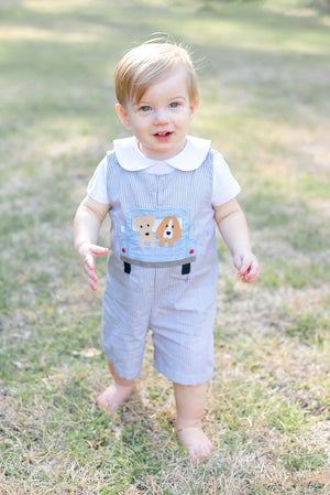 Grey gingham puppies in truck shortalls for babies, angle view showcasing adorable design and comfortable fit.