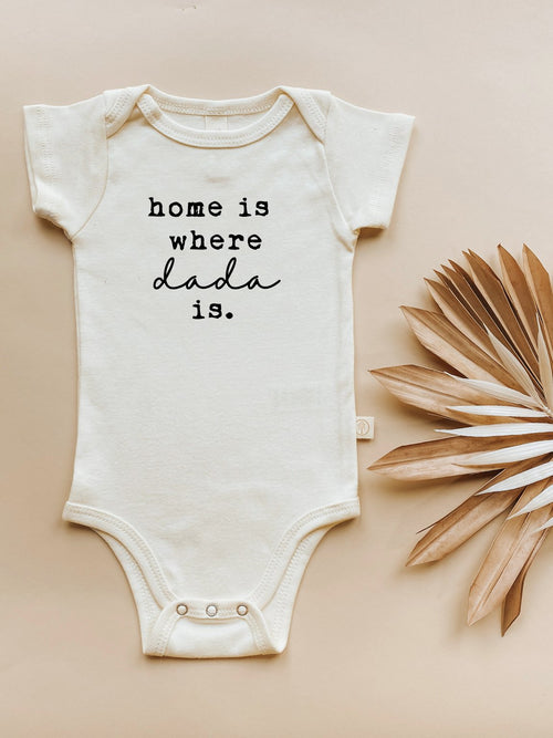 Organic baby bodysuit "Home is Where Dada Is" in short sleeves, displayed at an angle. Perfect for stylish infants.