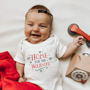 Graphic bodysuit for babies, "Home for the Holidays," short sleeve, angle view showcasing festive design.