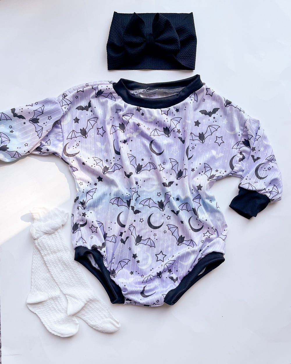Purple Halloween baby sweater romper for festive fall outfits. Perfect for little ones celebrating the season!